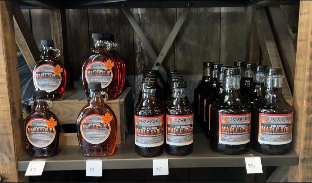 A shelf containing bottles of Wisconsin maple syrup for sale at the Pozarski family's storefront. 