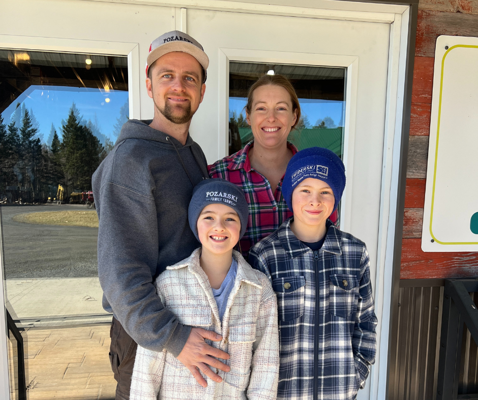 Wisconsin maple syrup producers Blake and Jessica Pozarski are standing with their sons Wyatt and Finley on their farm.